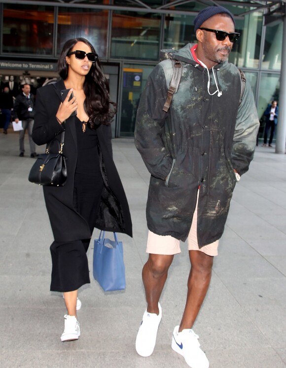 Idris Elba et sa compagne et fiancée Sabrina Dhowre arrivent à l'aéroport Heathrow, à Londres, le 15 avril 2019.