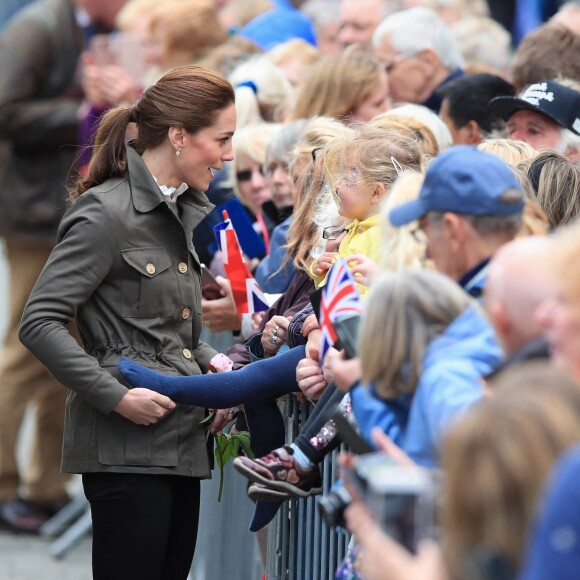 Kate Middleton, duchesse de Cambridge, saisit la jambe d'une fillette dans le public à Keswick dans le comté de Cumbria dans le nord de l'Angleterre, le 11 juin 2019.