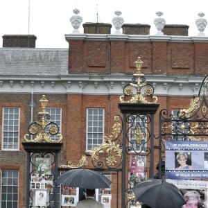 Le prince William et le prince Harry, le 30 août 2017, observant les témoignages d'affection du public à la mémoire de Lady Di sur les grilles du palais de Kensington, à la veille du 20e anniversaire de sa mort.