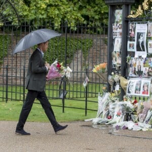 Le prince Harry, le 30 août 2017, déposant de fleurs et observant les témoignages d'affection du public à la mémoire de Lady Di sur les grilles du palais de Kensington, à la veille du 20e anniversaire de sa mort.