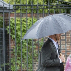 Le prince Harry, le 30 août 2017, déposant de fleurs et observant les témoignages d'affection du public à la mémoire de Lady Di sur les grilles du palais de Kensington, à la veille du 20e anniversaire de sa mort.