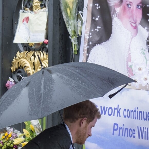 Le prince Harry, le 30 août 2017, déposant de fleurs et observant les témoignages d'affection du public à la mémoire de Lady Di sur les grilles du palais de Kensington, à la veille du 20e anniversaire de sa mort.