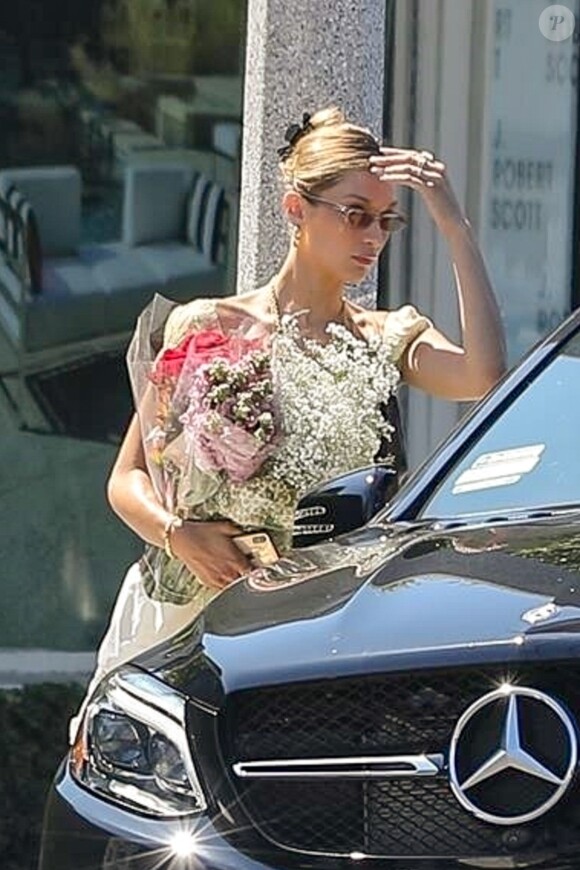 Exclusif - Bella Hadid est allée faire du shopping avec des amies à Los Angeles. Le mannequin a été aperçue avec un grand bouquet de fleurs dans les mains, alors qu'elle s'apprête à monter à bord de la voiture de son amie, le 4 aout 2019.