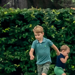 Le prince George de Cambridge et son frère le prince Louis jouant lors d'un match de polo disputé par le prince William à Wokinghan dans le Berkshire le 10 juillet 2019.