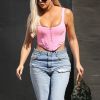 Khloe Kardashian porte un corset XXS rose, un jean déchiré et un sac camouflage Louis Vuitton à la sortie d'un studio dans le quartier de Calabasas à Los Angeles, le 3 septembre 2019