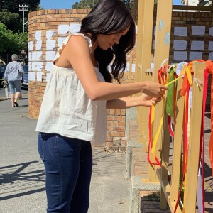 Meghan Markle, duchesse de Sussex, attache un ruban en mémoire de l'étudiante Uyinene Mrwetyana au bureau de poste où elle a été violée et assassinée le mois dernier. Le Cap, le 26 septembre 2019.