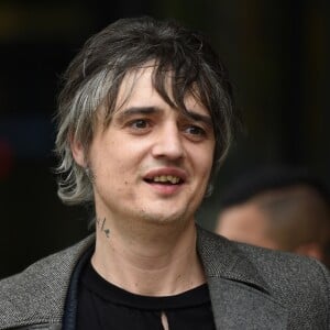 Le rocker Pete Doherty quitte les studios de la BBC après l'enregistrement de l'émission Radio Five Live, il porte un long manteau ulster en laine gris et l'étui de sa guitare à la main. Salford, le 9 mai 2019.