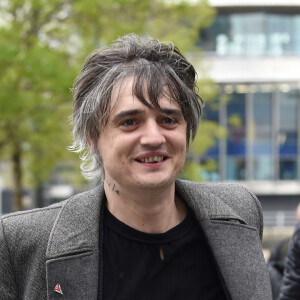 Le rocker Pete Doherty quitte les studios de la BBC après l'enregistrement de l'émission Radio Five Live, il porte un long manteau ulster en laine gris et l'étui de sa guitare à la main. Salford, le 9 mai 2019.