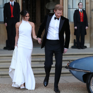 Meghan Markle et Harry quittent le château de Windsor à bord d'une Jaguar Type E cabriolet en tenue de soirée après leur cérémonie de mariage, pour se rendre à la réception à "Frogmore House" à Windsor le 19 mai 2018.