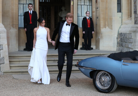 Meghan Markle et Harry quittent le château de Windsor à bord d'une Jaguar Type E cabriolet en tenue de soirée après leur cérémonie de mariage, pour se rendre à la réception à "Frogmore House" à Windsor le 19 mai 2018.