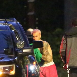 Exclusif - Justin Bieber enlève son sweatshirt et admire sa nouvelle couleur de cheveux rose dans le rétroviseur de sa jeep à Beverly Hills, Los Angeles. Le chanteur est allé jouer au basket avec des amis à la tombée de la nuit ! Le 24 novembre 2019.