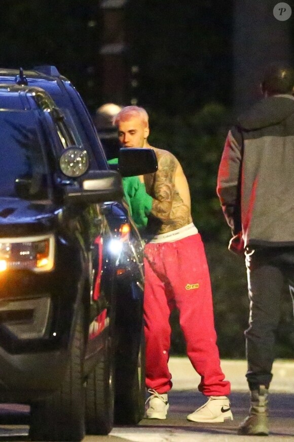 Exclusif - Justin Bieber enlève son sweatshirt et admire sa nouvelle couleur de cheveux rose dans le rétroviseur de sa jeep à Beverly Hills, Los Angeles. Le chanteur est allé jouer au basket avec des amis à la tombée de la nuit ! Le 24 novembre 2019.
