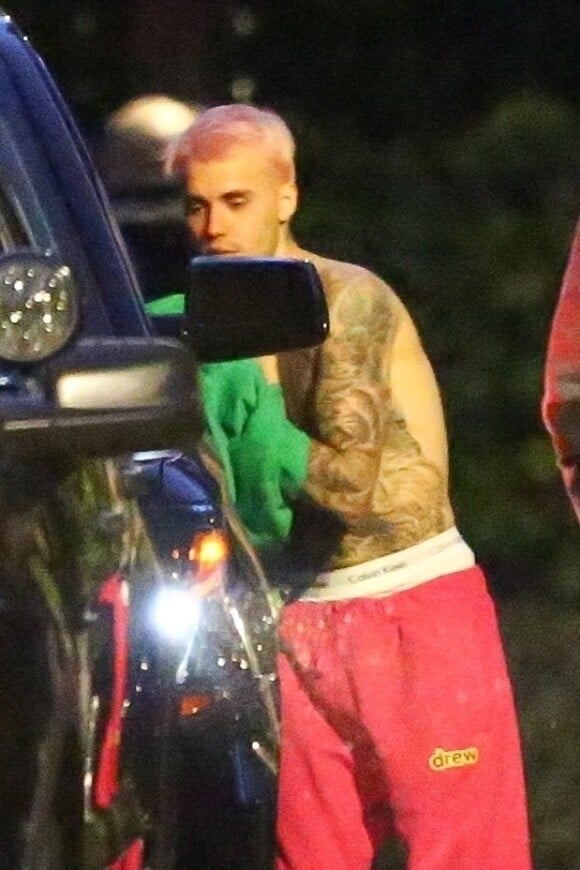 Exclusif - Justin Bieber enlève son sweatshirt et admire sa nouvelle couleur de cheveux rose dans le rétroviseur de sa jeep à Beverly Hills, Los Angeles. Le chanteur est allé jouer au basket avec des amis à la tombée de la nuit ! Le 24 novembre 2019.