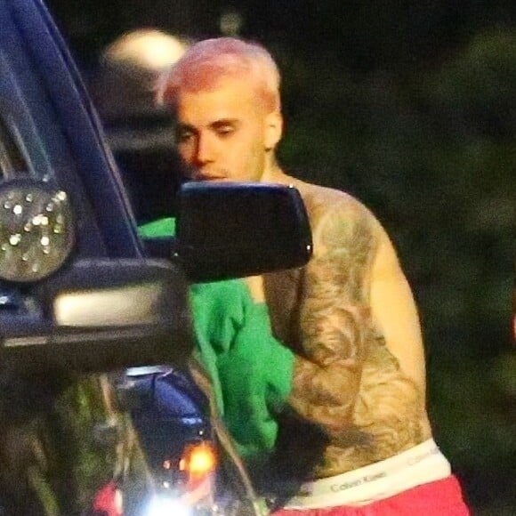 Exclusif - Justin Bieber enlève son sweatshirt et admire sa nouvelle couleur de cheveux rose dans le rétroviseur de sa jeep à Beverly Hills, Los Angeles. Le chanteur est allé jouer au basket avec des amis à la tombée de la nuit ! Le 24 novembre 2019.