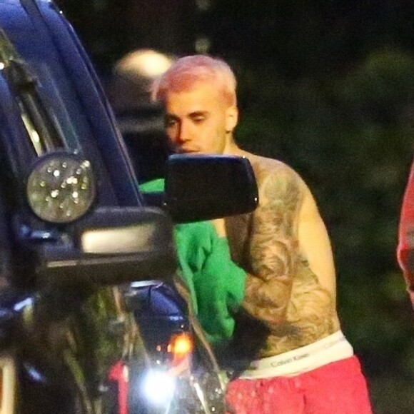 Exclusif - Justin Bieber enlève son sweatshirt et admire sa nouvelle couleur de cheveux rose dans le rétroviseur de sa jeep à Beverly Hills, Los Angeles. Le chanteur est allé jouer au basket avec des amis à la tombée de la nuit ! Le 24 novembre 2019.