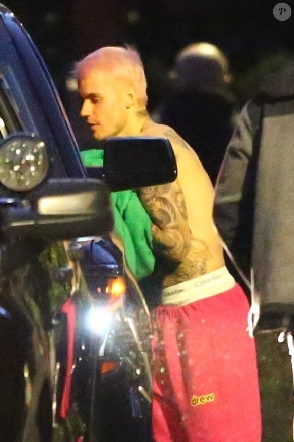 Exclusif - Justin Bieber enlève son sweatshirt et admire sa nouvelle couleur de cheveux rose dans le rétroviseur de sa jeep à Beverly Hills, Los Angeles. Le chanteur est allé jouer au basket avec des amis à la tombée de la nuit ! Le 24 novembre 2019.
