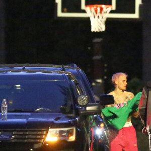 Exclusif - Justin Bieber enlève son sweatshirt et admire sa nouvelle couleur de cheveux rose dans le rétroviseur de sa jeep à Beverly Hills, Los Angeles. Le chanteur est allé jouer au basket avec des amis à la tombée de la nuit ! Le 24 novembre 2019.