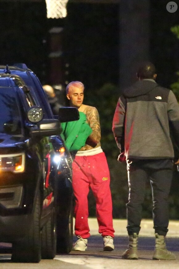 Exclusif - Justin Bieber enlève son sweatshirt et admire sa nouvelle couleur de cheveux rose dans le rétroviseur de sa jeep à Beverly Hills, Los Angeles. Le chanteur est allé jouer au basket avec des amis à la tombée de la nuit ! Le 24 novembre 2019.