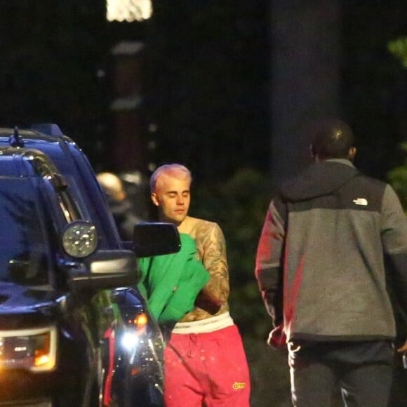 Exclusif - Justin Bieber enlève son sweatshirt et admire sa nouvelle couleur de cheveux rose dans le rétroviseur de sa jeep à Beverly Hills, Los Angeles. Le chanteur est allé jouer au basket avec des amis à la tombée de la nuit ! Le 24 novembre 2019.