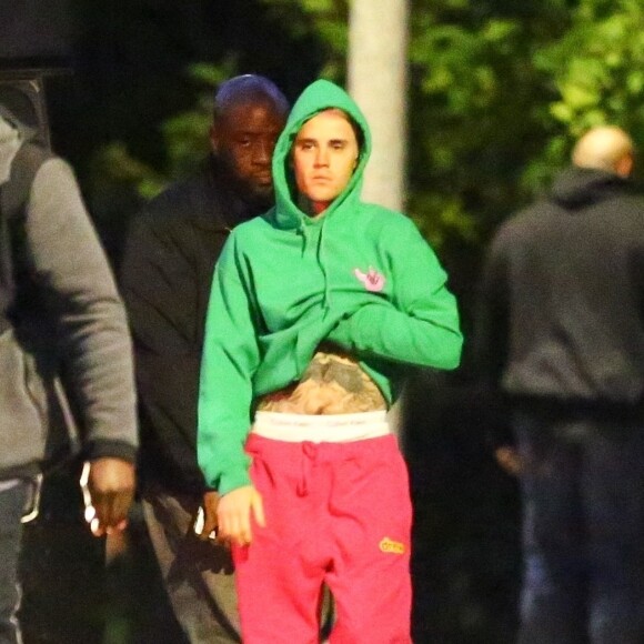 Exclusif - Justin Bieber enlève son sweatshirt et admire sa nouvelle couleur de cheveux rose dans le rétroviseur de sa jeep à Beverly Hills, Los Angeles. Le chanteur est allé jouer au basket avec des amis à la tombée de la nuit ! Le 24 novembre 2019.