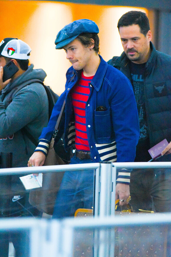Exclusif - Harry Styles arrive très stylé à l'aéroport de JFK à New York. Harry porte une casquette gavroche et du vernis à ongles de plusieurs couleurs, le 18 novembre 2019