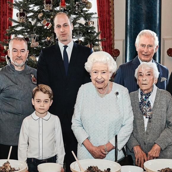 Le prince George de Cambridge prépare, sous le regard bienveillant du prince William, duc de Cambridge, du prince Charles, prince de Galles et de la reine Elisabeth II, des puddings de Noël, dans le cadre du lancement de l'initiative 'Together at Christmas' de la Royal British Legion au Palais de Buckingham, le 21 décembre 2019.