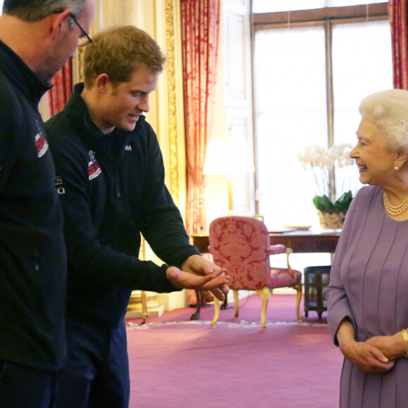 La reine Elisabeth II d'Angleterre et le prince Philip, duc d'Edimbourg, avec le prince Harry, les trois equipes du Royaume-Uni, des Etats-Unis et du Commonwealth, qui participeront au Walking With The Wounded South Pole Allied Challenge, au palais de Buckingham a Londres. Le 13 novembre 2013