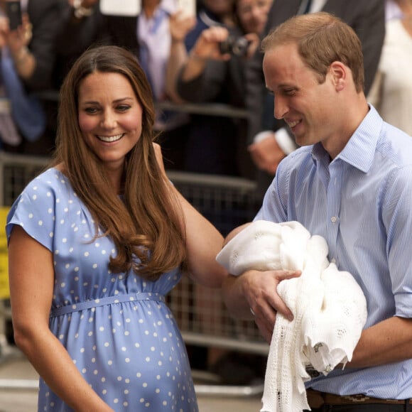 Le prince William et Kate Middleton, duchesse de Cambridge quittent l'hôpital St-Mary avec leur fils George de Cambridge à Londres le 23 juillet 2013.