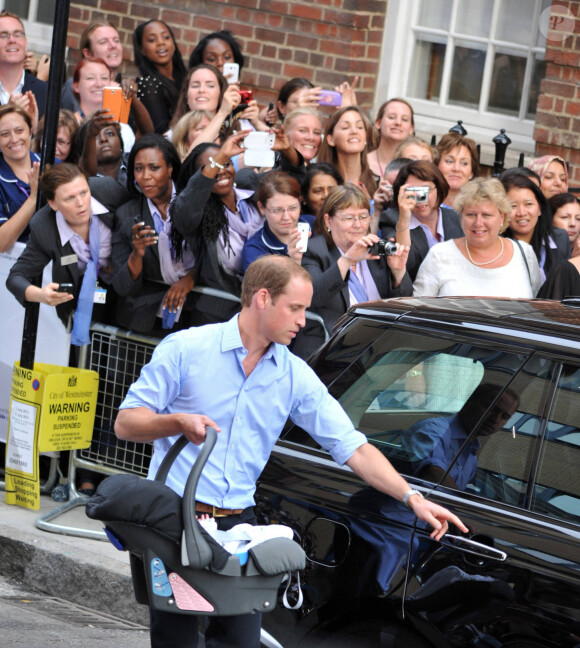 Le prince William et Kate Middleton, duchesse de Cambridge quittent l'hôpital St-Mary avec leur fils George de Cambridge à Londres le 23 juillet 2013.