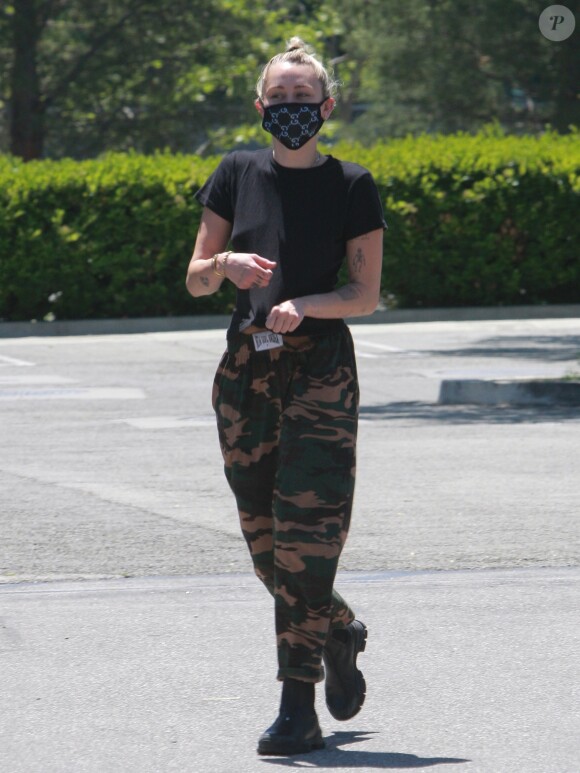 Miley Cyrus (masque de protection Gucci) et son compagnon Cody Simpson sortent du supermarché Erewhon Market avec un caddie plein à Calabasas le 23 avril 2020.