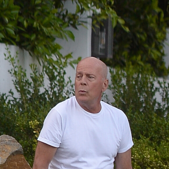 Exclusif - Bruce Willis est assis pieds nus sur un rocher et regarde passer les voitures sur Sunset Boulevard à Los Angeles, le 22 septembre 2019.