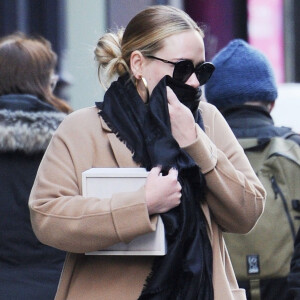 Exclusif - Adele se cache des photographes à la sortie d'un immeuble à New York, le 2 avril 2019.