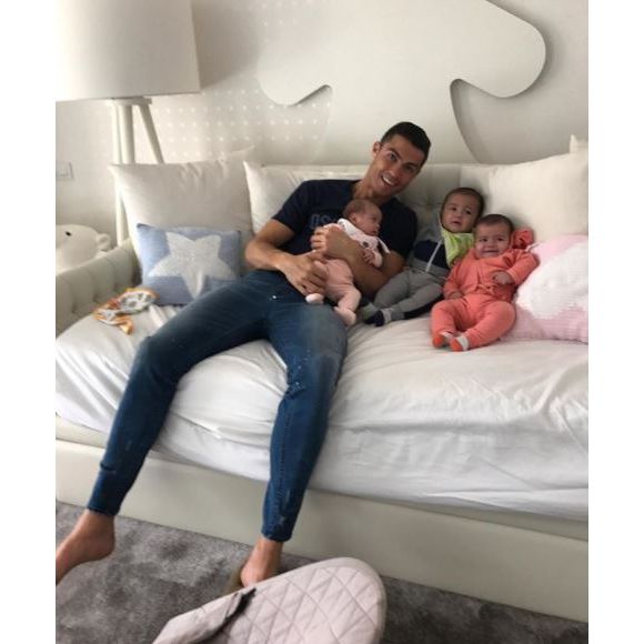 Cristiano Ronaldo "retenu prisonnier" par ses trois bébés, Alana Martina et les jumeaux Eva et Mateo, dans une photo partagée sur Instagram le 26 décembre 2017.