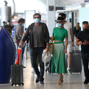 Exclusif - Laeticia Hallyday et son compagnon Pascal Balland arrivent à l'aéroport Roissy CDG après une échappée de trois jours à Florence, sans enfants, le 30 juin 2020.