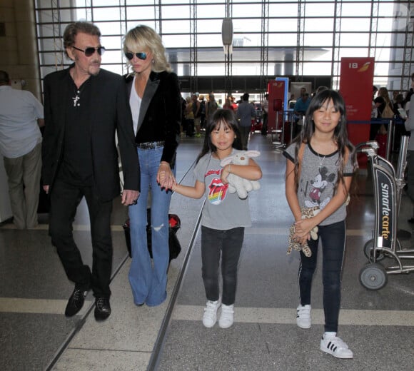 Johnny Hallyday avec sa femme Laeticia et ses enfants Jade et Joy en partance pour Paris arrivent à l'aéroport Lax de Los Angeles le 25 juin 2016.