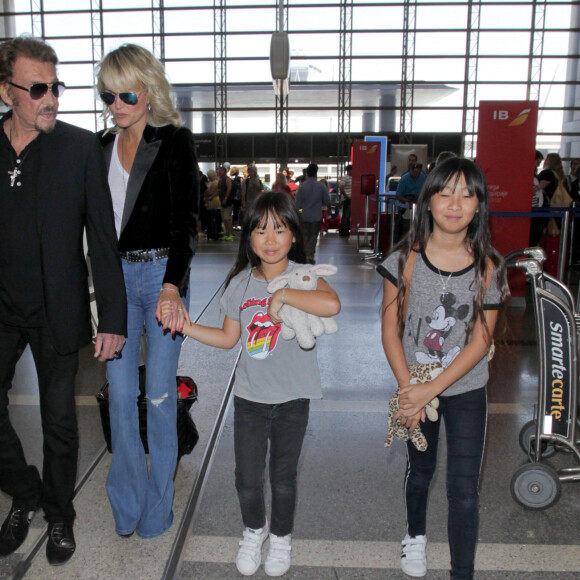 Johnny Hallyday avec sa femme Laeticia et ses enfants Jade et Joy en partance pour Paris arrivent à l'aéroport Lax de Los Angeles le 25 juin 2016.