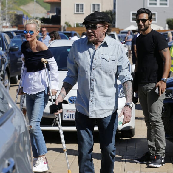 Johnny Hallyday avec sa femme Laeticia, qui marche toujours avec des béquilles, accompagnés de Maxim Nucci (Yodelice), arrivent au restaurant "Soho House" à Malibu, le 09 mars 2017.