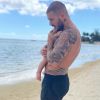M. Pokora avec son fils Isaiah (10 mois) dans les bras, sur une magnifique plage de l'île Maurice le 24 octobre 2020.