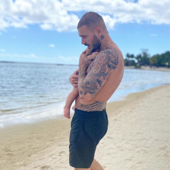 M. Pokora avec son fils Isaiah (10 mois) dans les bras, sur une magnifique plage de l'île Maurice le 24 octobre 2020.