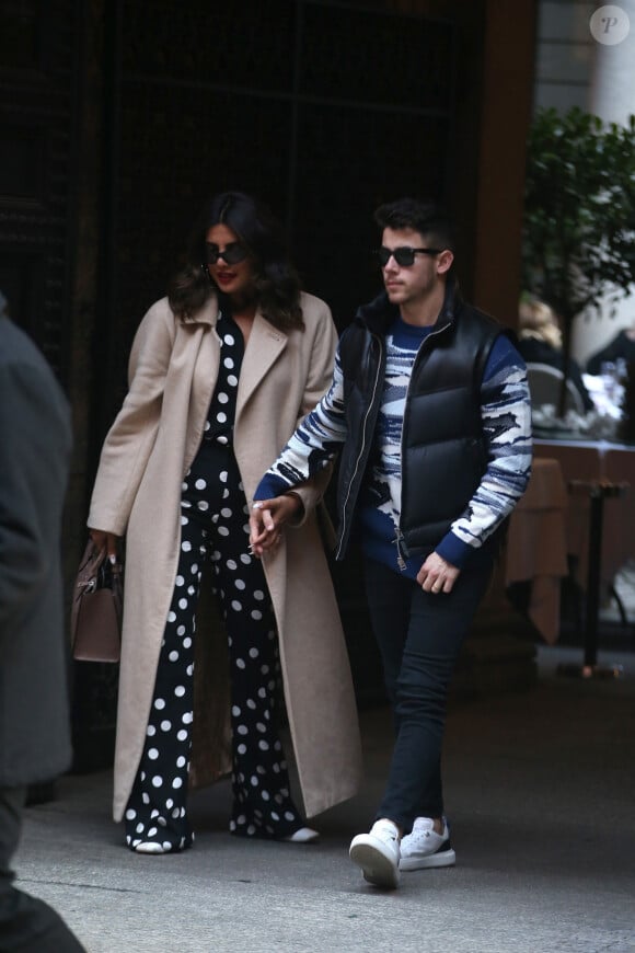 Nick Jonas et sa femme Priyanka Chopra déjeunent en terrasse au restaurant Salumaio à Milan, le 14 février 2020. Un vendeur ambulant essaye de leur vendre un bracelet.