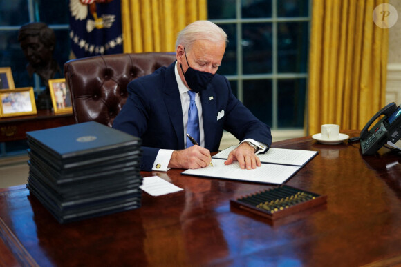 Le 46ème président des Etats-Unis Joe Biden lors de la signature de ses premiers décrets, juste après son investiture, dans le bureau ovale de la Maison Blanche à Washington. Le 20 janvier 2021