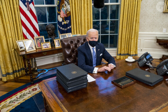Le 46ème président des Etats-Unis Joe Biden lors de la signature de ses premiers décrets, juste après son investiture, dans le bureau ovale de la Maison Blanche à Washington. Le 20 janvier 2021