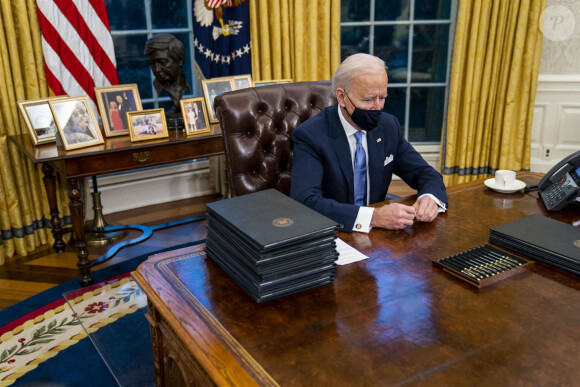 Le 46ème président des Etats-Unis Joe Biden lors de la signature de ses premiers décrets, juste après son investiture, dans le bureau ovale de la Maison Blanche à Washington. Le 20 janvier 2021