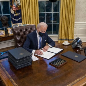 Le 46ème président des Etats-Unis Joe Biden lors de la signature de ses premiers décrets, juste après son investiture, dans le bureau ovale de la Maison Blanche à Washington. Le 20 janvier 2021