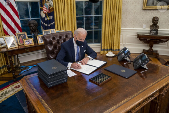 Le 46ème président des Etats-Unis Joe Biden lors de la signature de ses premiers décrets, juste après son investiture, dans le bureau ovale de la Maison Blanche à Washington. Le 20 janvier 2021