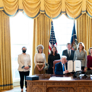 Donald Trump, accompagné de la première dame Melania Trump et de ses invités, signe H.R.473 pour autoriser la construction du monument Every Word We Utter pour le district de Columbia dans le bureau ovale de la Maison Blanche le 17 décembre 2020.