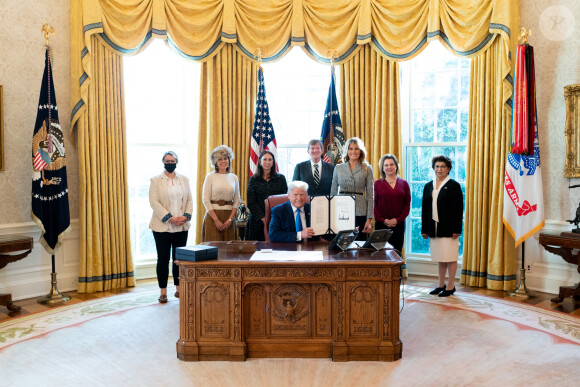 Donald Trump, accompagné de la première dame Melania Trump et de ses invités, signe H.R.473 pour autoriser la construction du monument Every Word We Utter pour le district de Columbia dans le bureau ovale de la Maison Blanche le 17 décembre 2020.