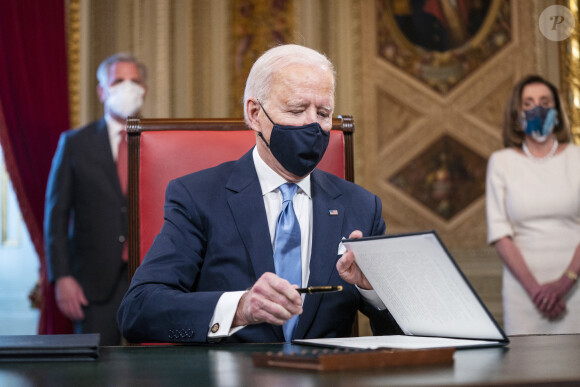 Le 46ème président des Etats-Unis Joe Biden lors de la signature de ses premiers décrets, juste après son investiture, dans le bureau ovale de la Maison Blanche à Washington. Le 20 janvier 2021 
