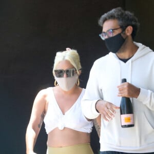 Exclusif - Lady Gaga et son compagnon Michael Polansky, munis de masques de protection contre le coronavirus (Covid-19), quittent un restaurant italien de Malibu les bras chargés de victuailles. Le 14 juin 2020.
