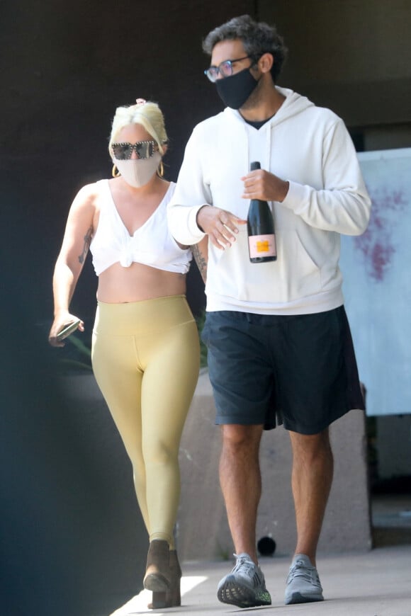 Exclusif - Lady Gaga et son compagnon Michael Polansky, munis de masques de protection contre le coronavirus (Covid-19), quittent un restaurant italien de Malibu les bras chargés de victuailles. Le 14 juin 2020.